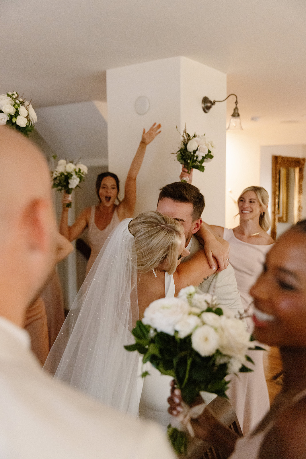 Bride and groom sharing a kiss while their bridal party shares the excitement after their ceremony.
