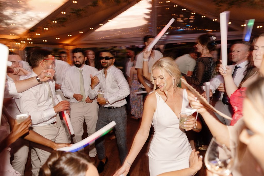 Bridal party joining the couple on the dance floor, surrounded by laughter at The Griffin House
