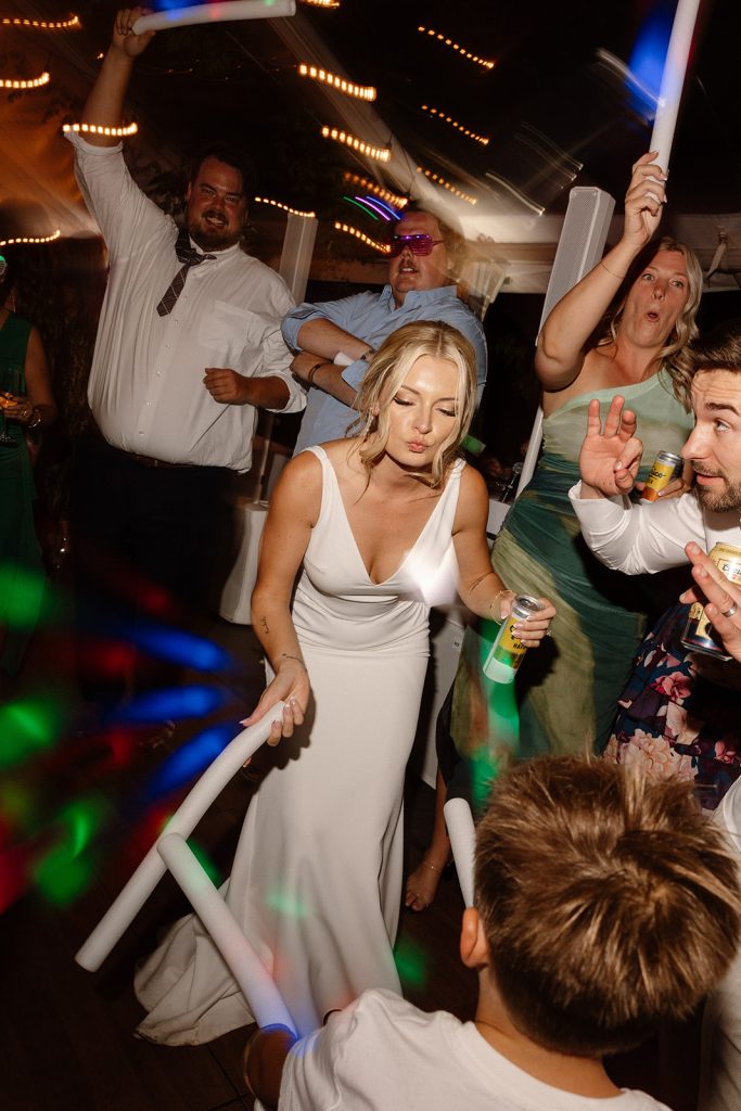Candid moment of friends dancing energetically during the wedding reception at The Griffin House